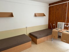 Lôžka a pracovný stôl v izbe budovy H5 ubytovacieho zariadenia Hliny V.